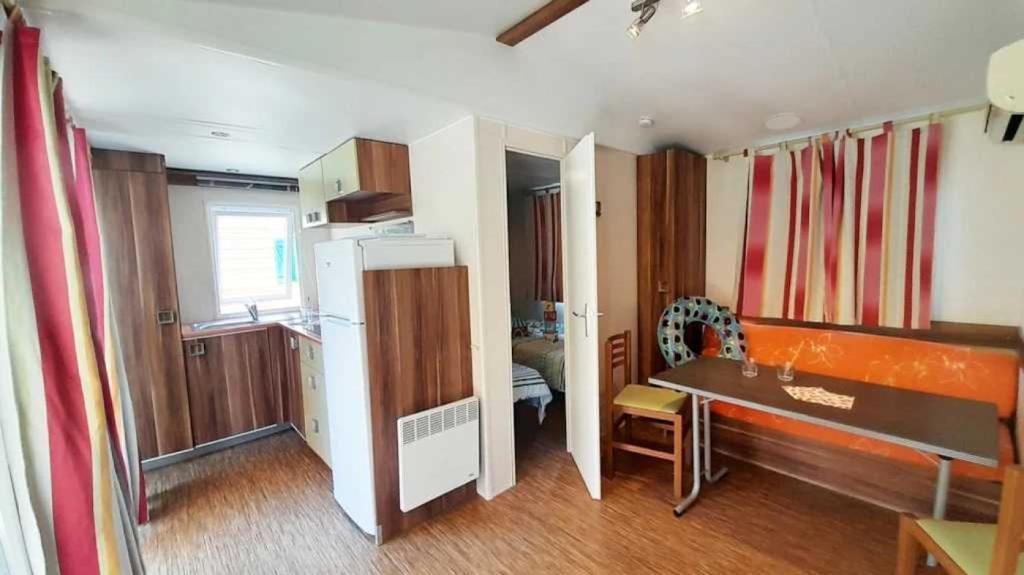 une petite cuisine avec une table et un réfrigérateur dans l'établissement Camping 3 étoiles - Piscine - ccbaehg, à Mézel