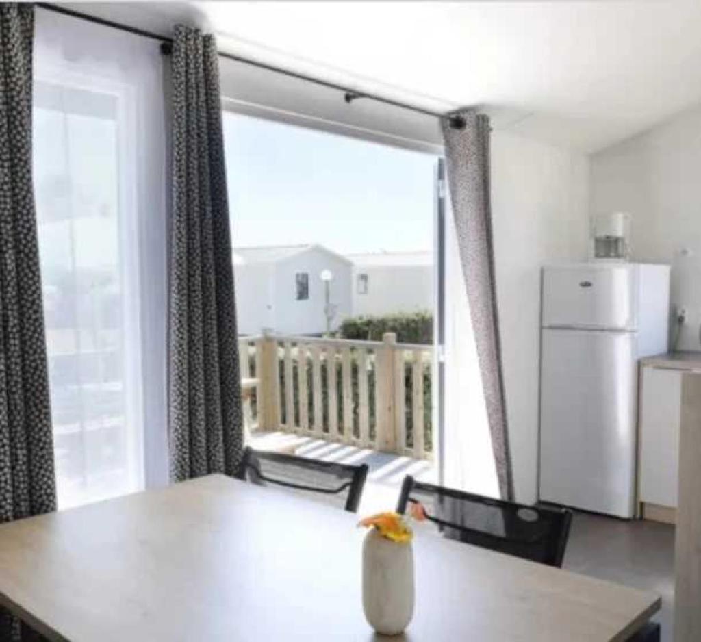 une cuisine avec une table et une vue sur un balcon dans l'établissement Camping 3 étoiles - Piscine - eehghh, à Ploemeur