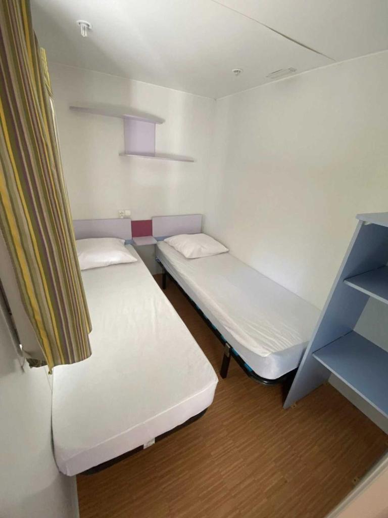 Cette petite chambre comprend 2 lits. dans l'établissement Camping 3 étoiles - Piscine - cca0gbf, à Saint-Jean-Pla-de-Corts 36 autres photos