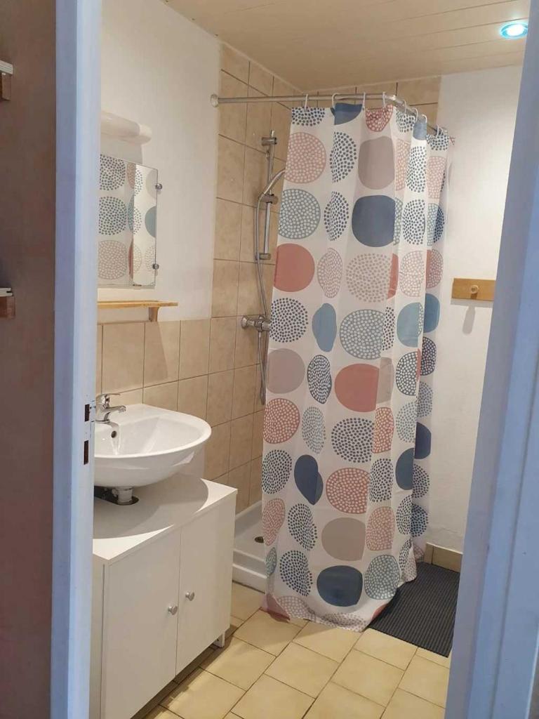 une salle de bain avec un rideau de douche et un lavabo dans l'établissement Camping 3 étoiles - Piscine - eeicbi, à Le Change