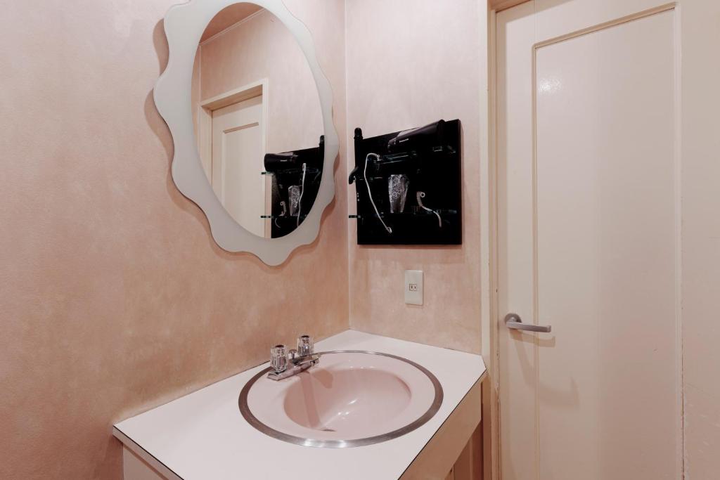 une salle de bain avec un lavabo et un miroir dans l'établissement Asahikawa Hotel UNION-Adult Only, à Asahikawa