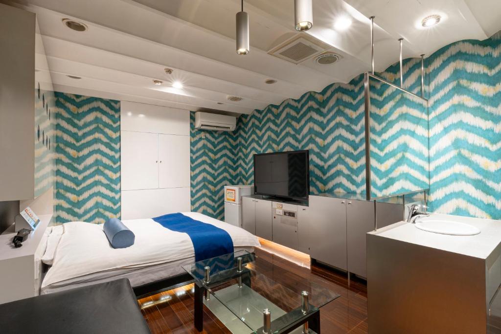 - une chambre à l'hôpital avec un lit et une télévision dans l'établissement Asahikawa Hotel COLOR'S-Adult Only, à Asahikawa