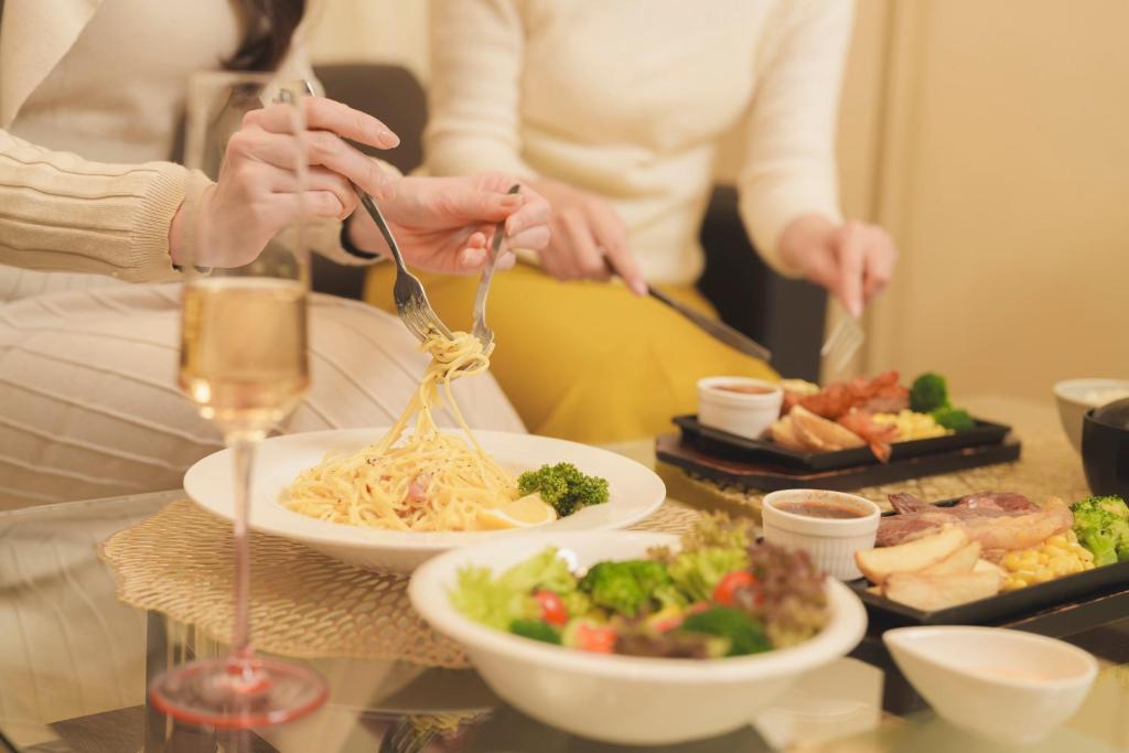Un groupe de personnes mangeant de la nourriture sur une table dans l'établissement 袖ヶ浦c COAST HIKE HOTEL, à Sodegaura 32 autres photos