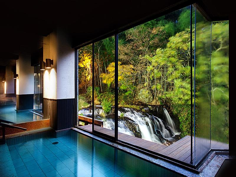 une chambre avec vue sur une cascade à travers une fenêtre dans l'établissement Shosuke-no-Yado Takinoyu, à Aizuwakamatsu