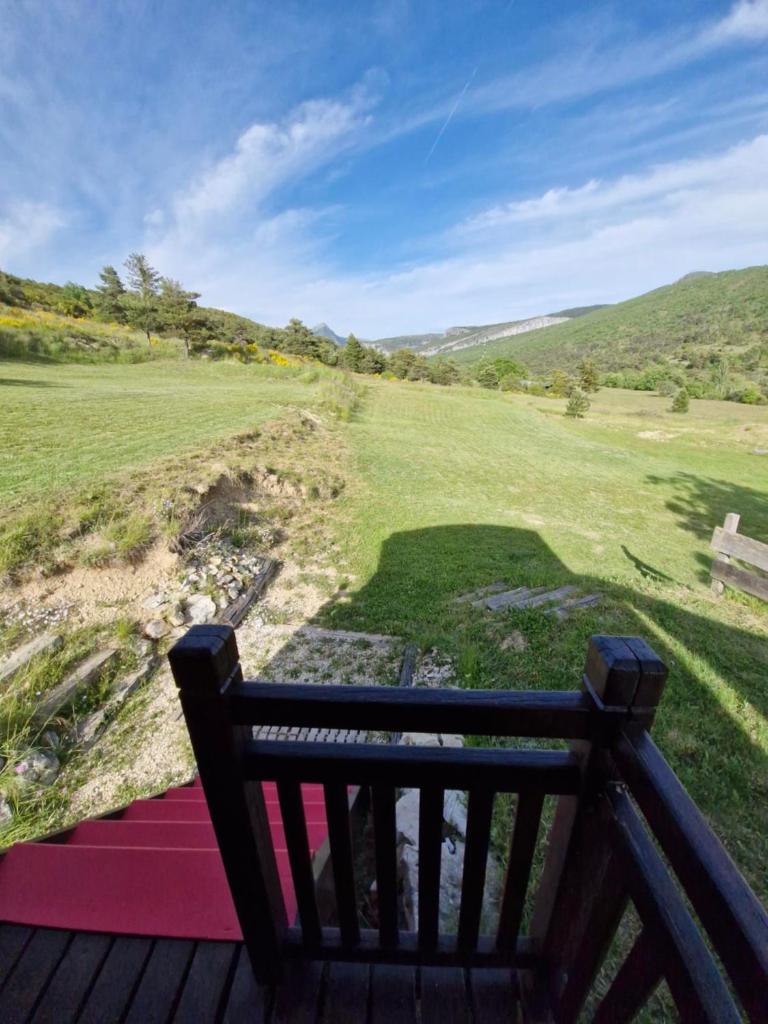 un banc sur une terrasse avec vue sur un champ dans l'établissement Roulotte du domaine de la Graou, à La Palud-sur-Verdon