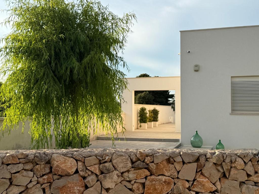 une maison avec un mur en pierre et un arbre dans l'établissement Abate Filippo apartment, à Nardò