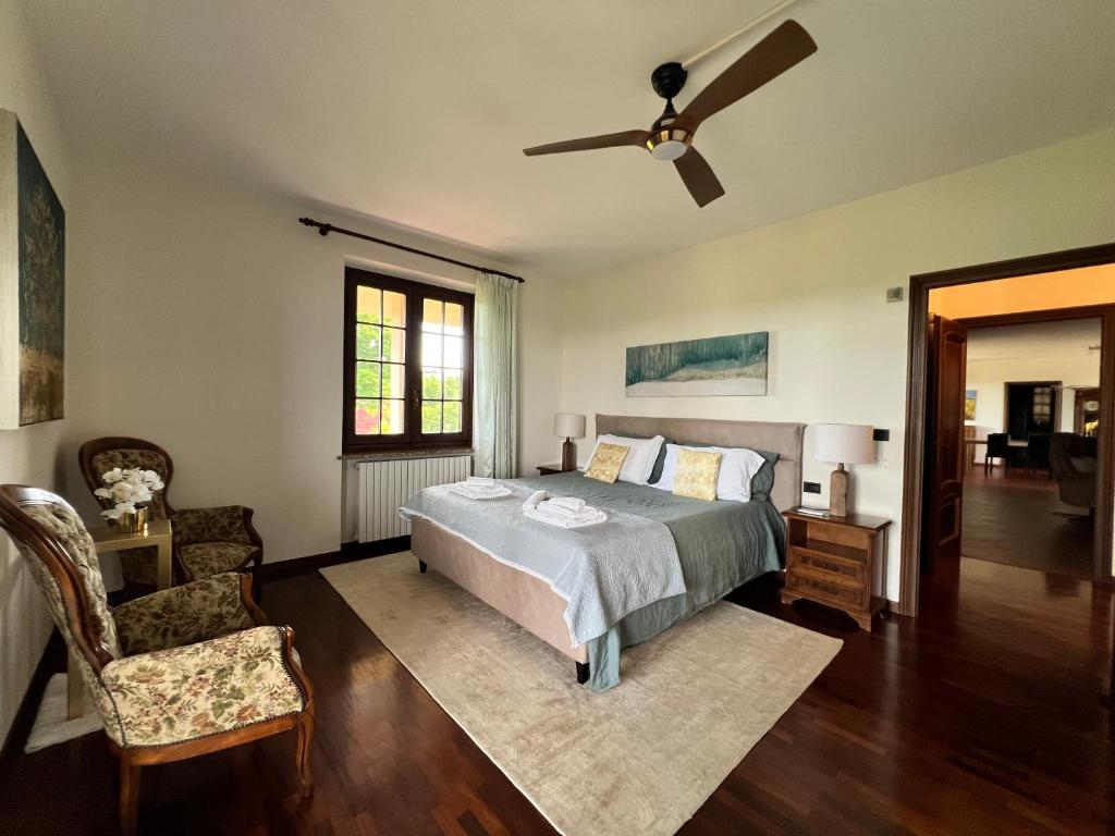 une chambre avec un lit et un ventilateur de plafond dans l'établissement Villa Jilla, à Calosso