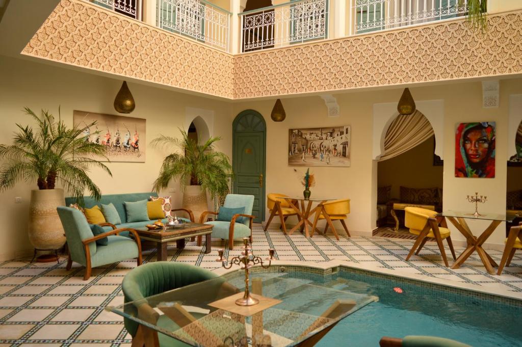 - un salon avec un billard, des tables et des chaises dans l'établissement Riad Jalina, à Marrakech