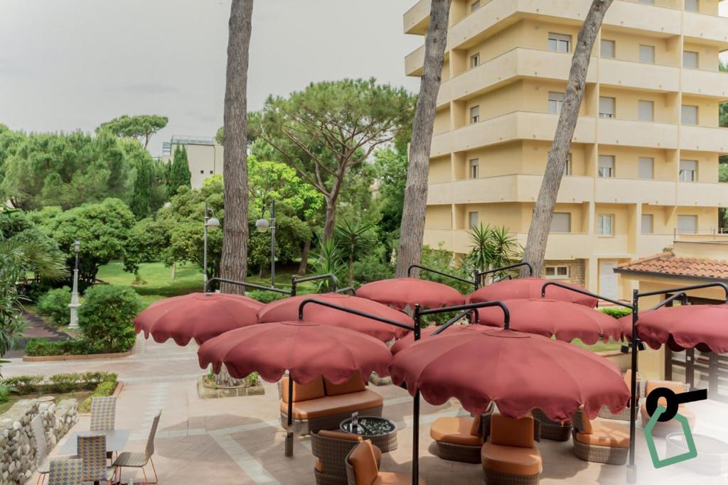 un tas de parapluies rouges devant un bâtiment dans l'établissement Hotiday Marina di Bibbona, à Marina di Bibbona