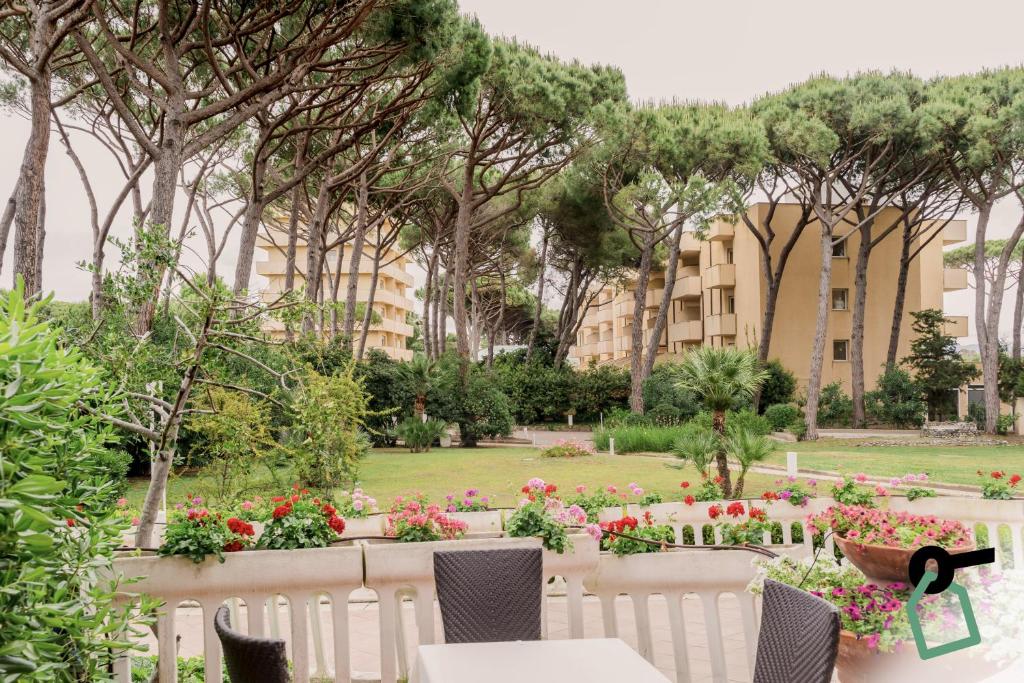 un jardin fleuri et un bâtiment en arrière-plan dans l'établissement Hotiday Marina di Bibbona, à Marina di Bibbona