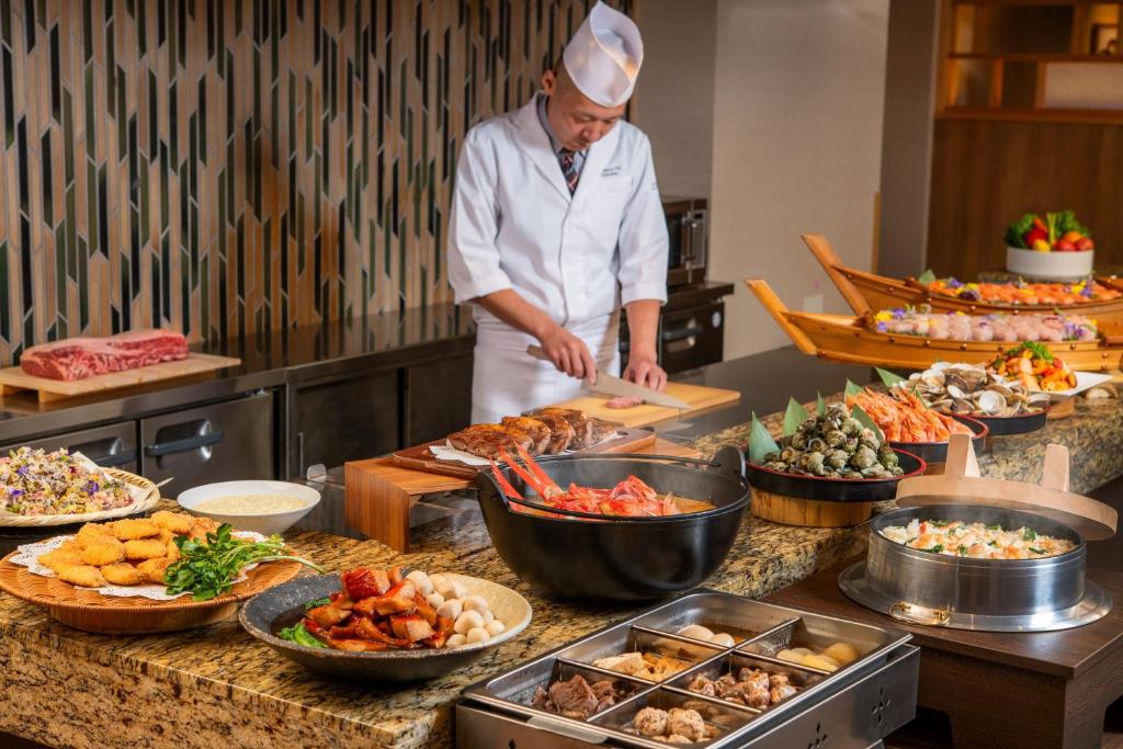 - un chef debout dans une cuisine préparant des plats dans l'établissement KAMENOI HOTEL Kamogawa, à Kamogawa