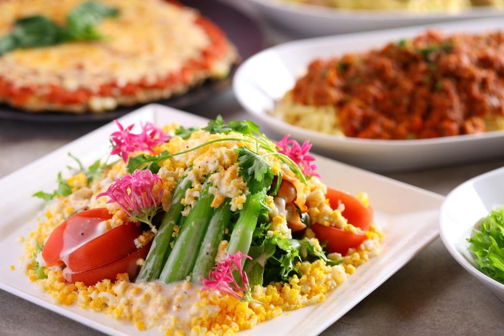 une assiette de nourriture avec des légumes sur une table dans l'établissement KAMENOI HOTEL Kamogawa, à Kamogawa