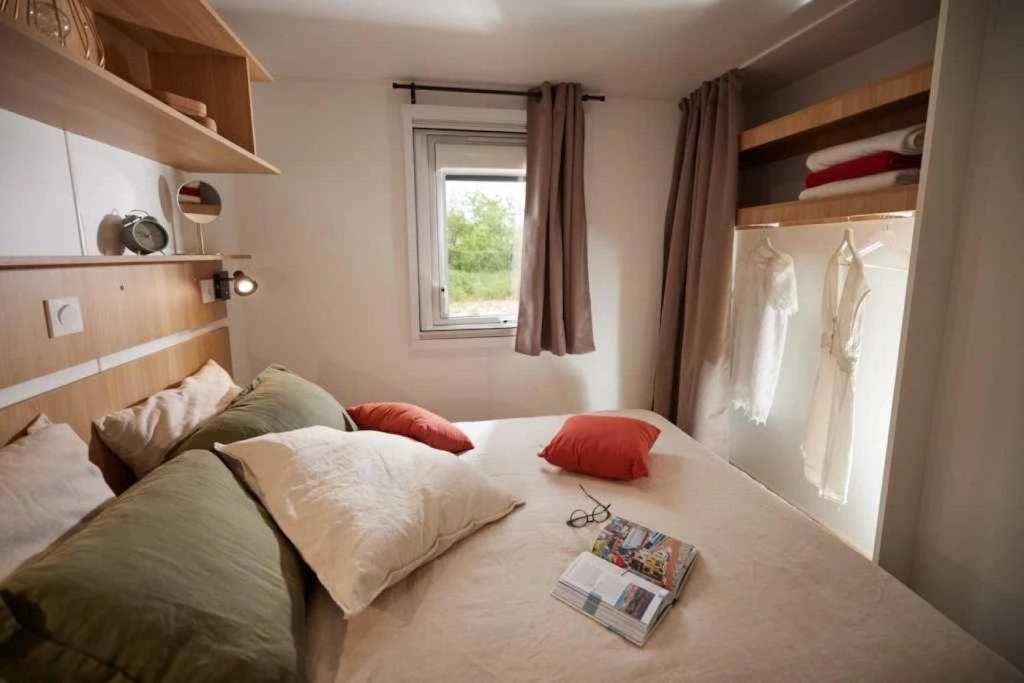 - une chambre avec un lit et un livre dans l'établissement Camping 3 étoiles - Parc aquatique - cca0gdc, à Saint-Maime 37 autres photos
