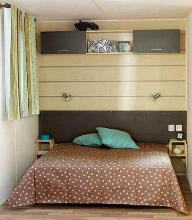 une chambre avec un lit avec deux oreillers bleus dans l'établissement Camping 4 étoiles - Piscine - ccaaagh, à Carennac