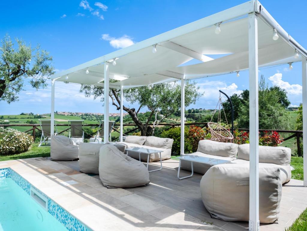 un pavillon blanc à côté d'une piscine dans l'établissement Casal Tartàn - Private Villa with SPA & Pool, à San Costanzo