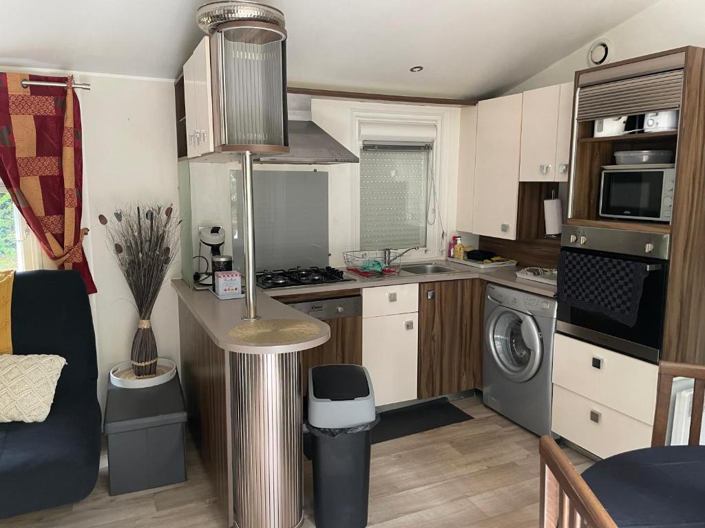 une petite cuisine avec un évier et une cuisinière dans l'établissement Mobile Home PREMIUM AZUR climatisé tout équipé, à Saint-Chéron