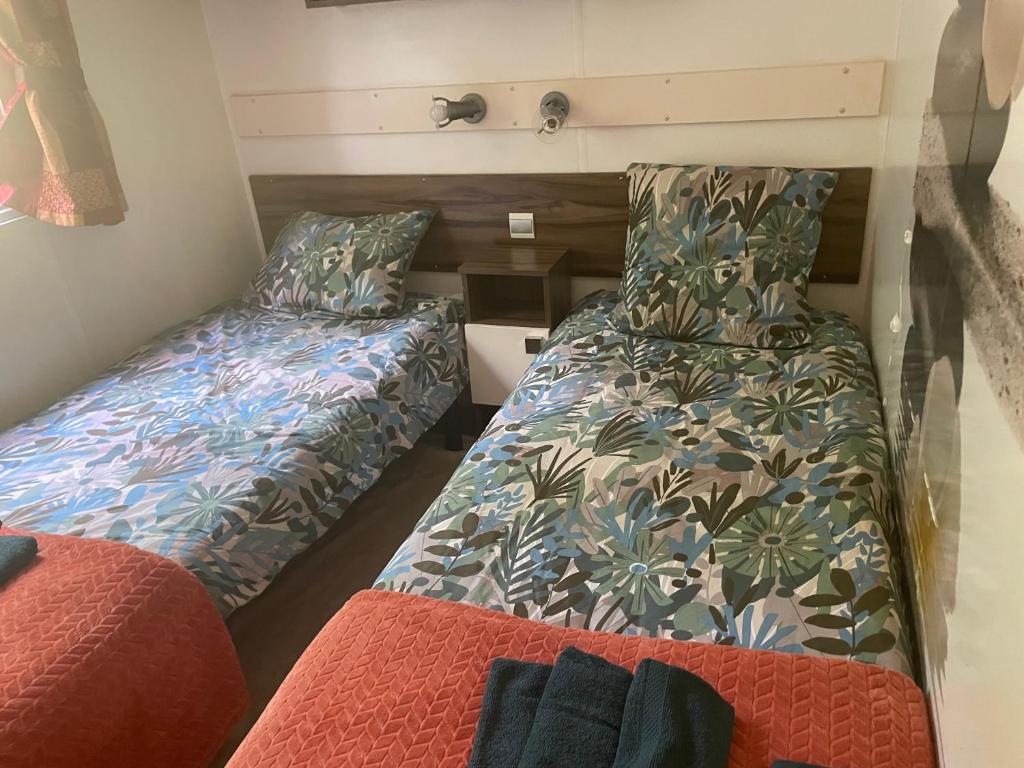 une petite pièce avec un lit et un canapé dans l'établissement Mobile Home PREMIUM AZUR climatisé tout équipé, à Saint-Chéron