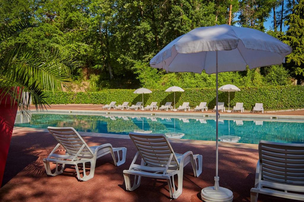 deux chaises et un parasol à côté d'une piscine dans l'établissement Mobile Home PREMIUM AZUR climatisé tout équipé, à Saint-Chéron
