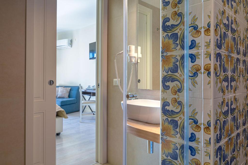 une salle de bain avec un lavabo et des toilettes dans une chambre dans l'établissement Hotel Rivage Taormina, à Taormine