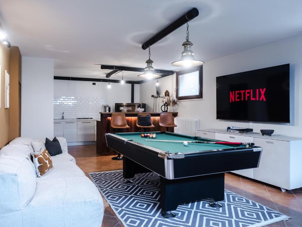 un salon avec une table de billard et une télévision dans l'établissement Casal Tartàn - Private Villa with SPA & Pool, à San Costanzo