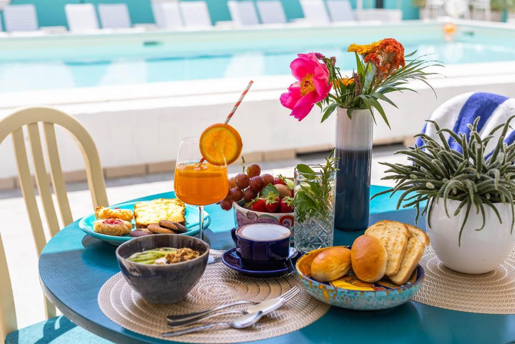 une table bleue avec des aliments pour le petit-déjeuner et une boisson dans l'établissement Hotel Portofino, à Lido di Jesolo