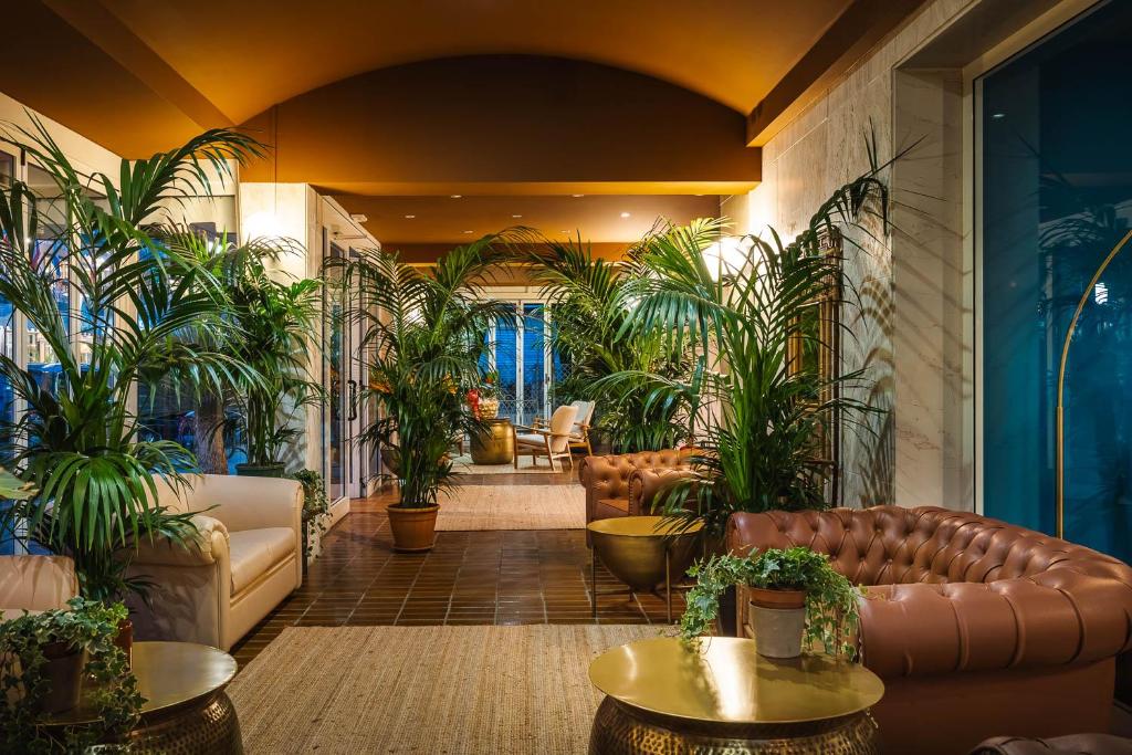 un hall d'entrée avec des meubles en cuir et des plantes en pot dans l'établissement Hotel Portofino, à Lido di Jesolo