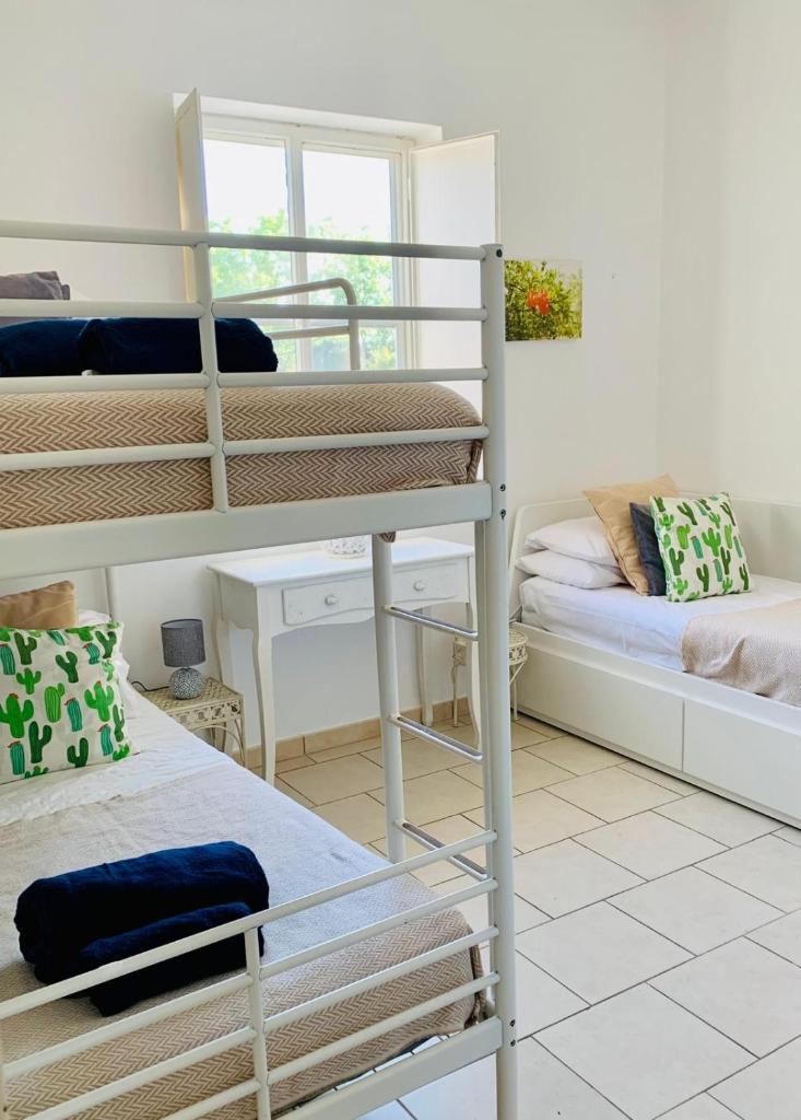 une chambre avec deux lits superposés et un bureau dans l'établissement Villa Bona Dea, à San Michele Salentino