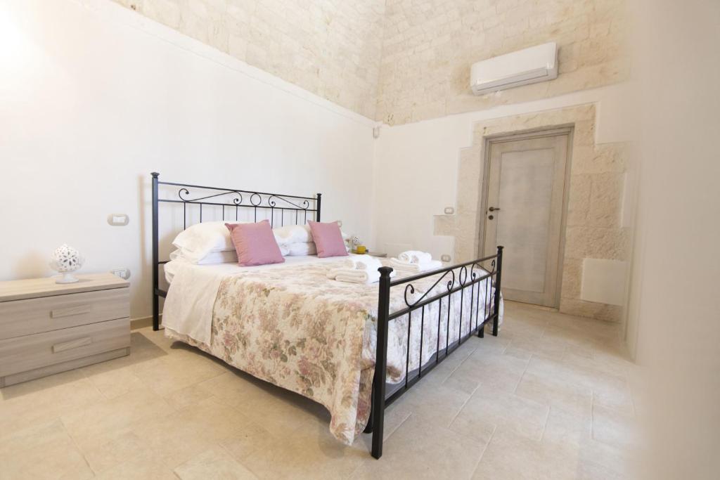 une chambre avec un lit avec des oreillers roses dans l'établissement La catena, à Martina Franca 29 autres photos