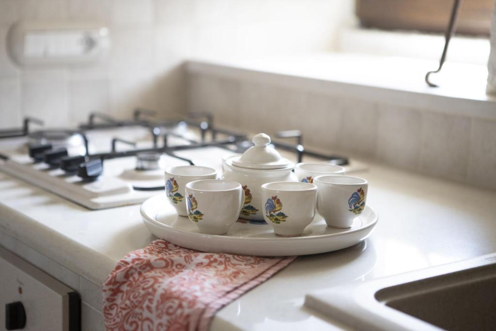 un groupe de tasses sur une assiette sur un comptoir de cuisine dans l'établissement La catena, à Martina Franca