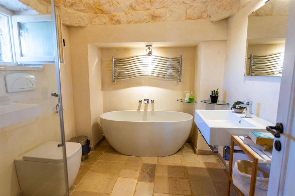 une salle de bain avec une grande baignoire et un lavabo dans l'établissement Villa Trullo Selva Grande by Villa Plus, à Martina Franca 18 autres photos
