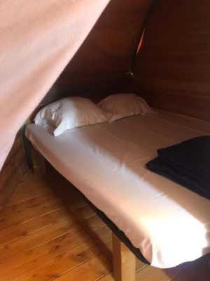 - un lit dans une tente avec 2 oreillers dans l'établissement Camping 4 étoiles - Piscine - eed0aa, à Estipouy