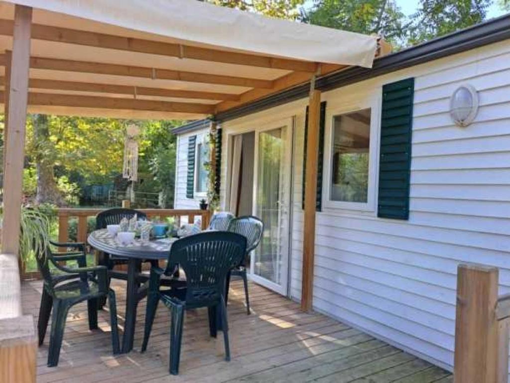 un patio avec une table et des chaises sur une terrasse dans l'établissement Camping 3 étoiles - Piscine - eeebbh, à Saint-Céré
