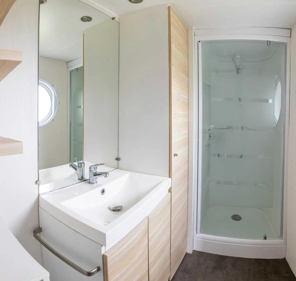 une salle de bain blanche avec un lavabo et une douche dans l'établissement Camping 5 étoiles - Parc aquatique - eebfed, à Sainte-Catherine-de-Fierbois