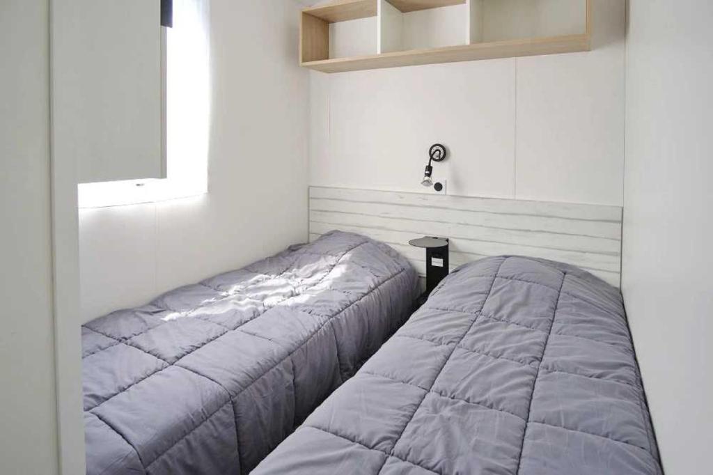 - une chambre avec 2 lits dans une chambre avec une fenêtre dans l'établissement Camping 5 étoiles - Parc aquatique - eeibhf, à Bretignolles-sur-Mer