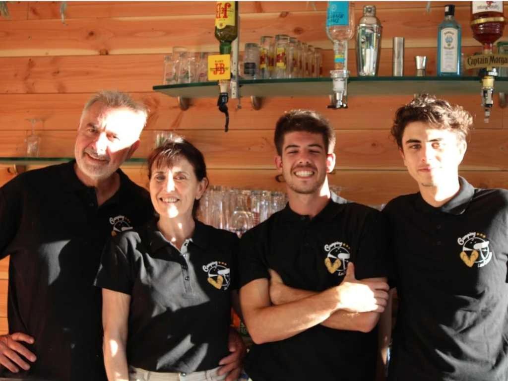 un groupe de quatre hommes debout dans un bar dans l'établissement Camping 3 étoiles - Piscine - ccaffbe, à Bormes-les-Mimosas