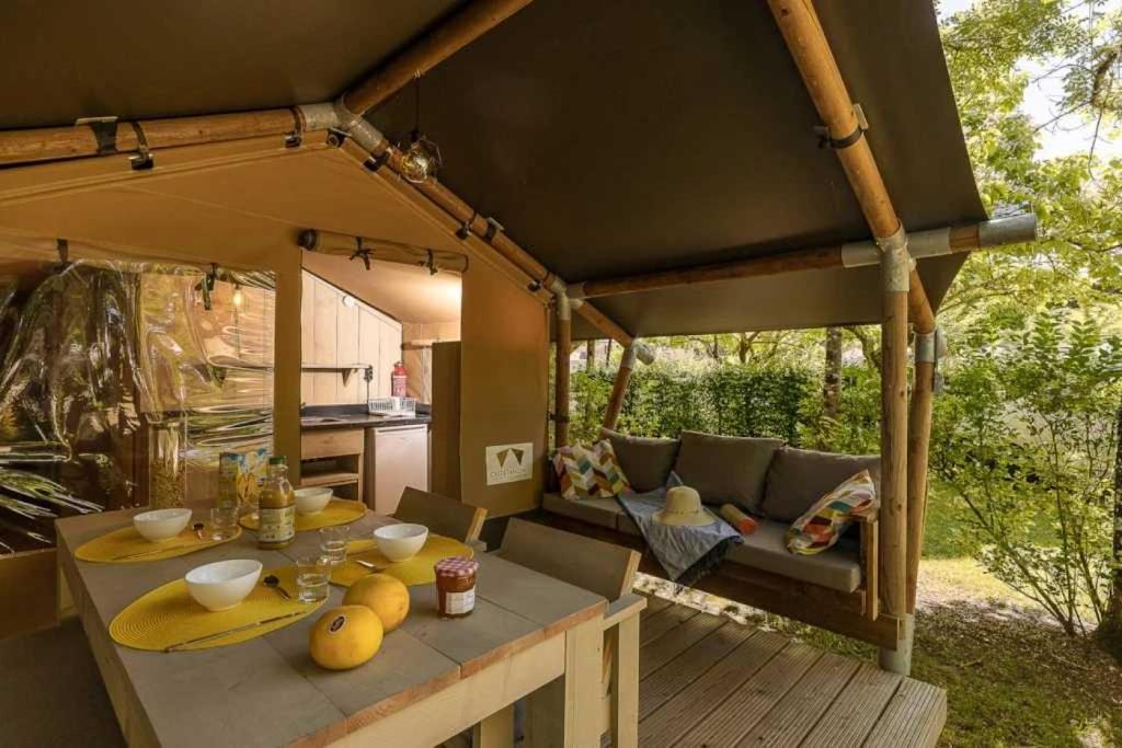 - un kiosque avec une table et un canapé dans l'établissement Camping 3 étoiles - Piscine - ccbb0if, à Montpon-Ménestérol