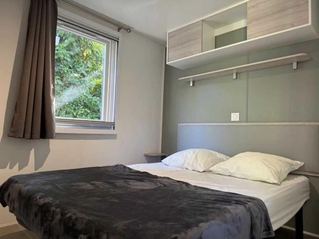 une chambre avec un grand lit avec une fenêtre dans l'établissement Camping 4 étoiles - Piscine - ccbacgb, à Rosans
