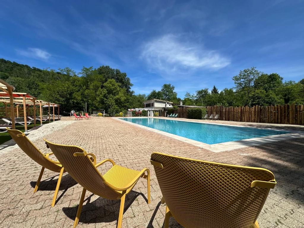 - deux chaises assises à côté de la piscine dans l'établissement Chalet 6 places, à Saint-Thomas-en-Royans