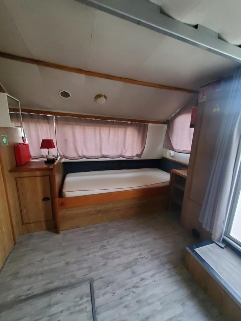 Cette petite chambre comprend un lit à l'arrière d'un bateau. dans l'établissement BATEAU - Jolie pénichette sur région touristique., à Bellegarde