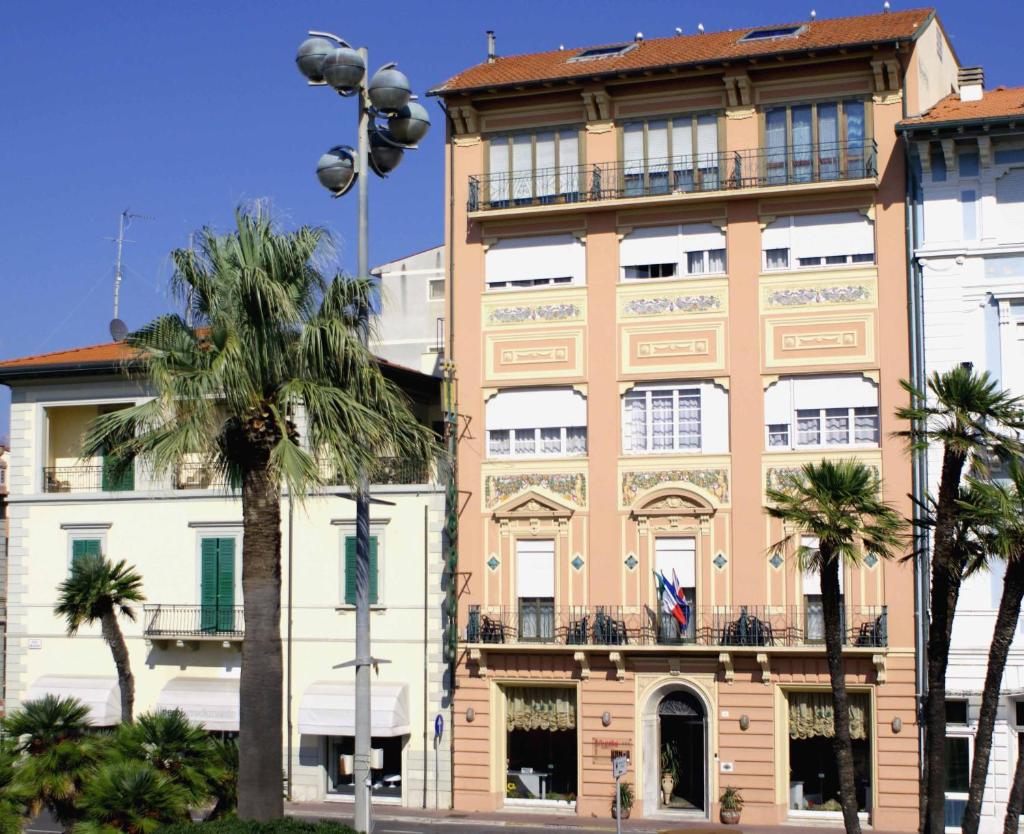 un bâtiment avec des palmiers devant dans l'établissement Hotel Liberty, à Viareggio