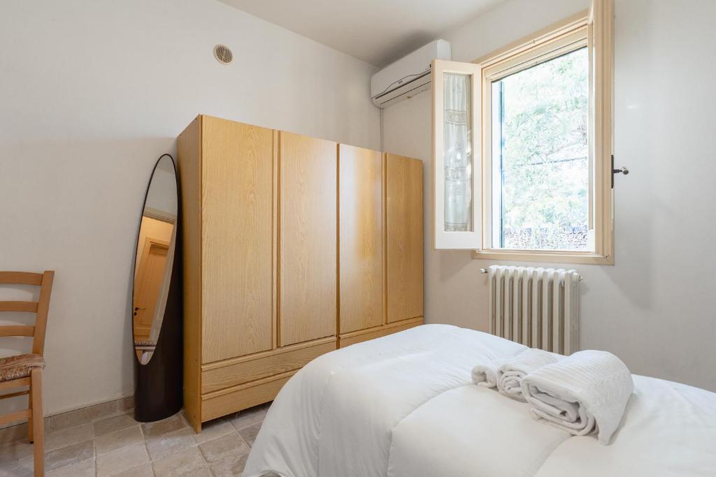 une chambre avec un lit et une armoire en bois dans l'établissement Casale Eucalipto, à Faccia di Trippa 28 autres photos