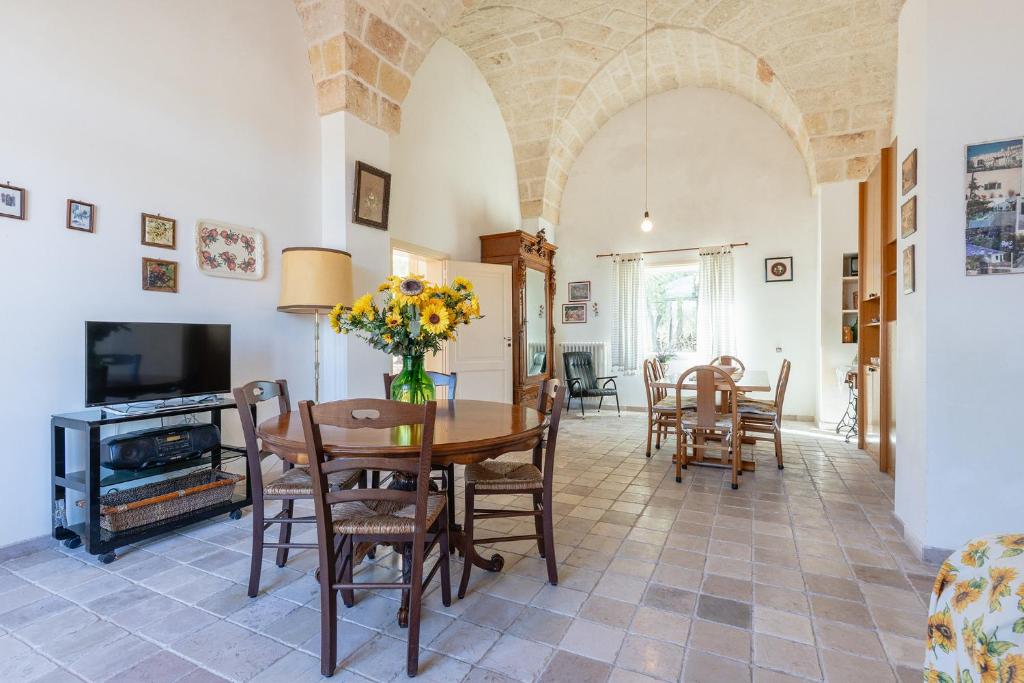 une salle à manger et un salon avec une table et des chaises dans l'établissement Casale Eucalipto, à Faccia di Trippa
