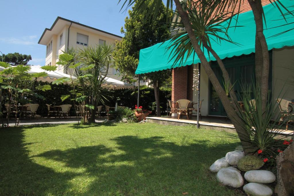 une cour avec un palmier et un bâtiment dans l'établissement Hotel Vera, à Marina di Massa