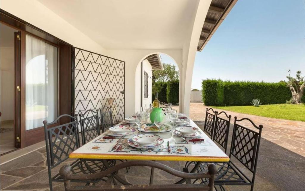 - une table avec des assiettes et de la vaisselle sur une terrasse dans l'établissement Villa Carrisi - Salento Reservation, à Parabita
