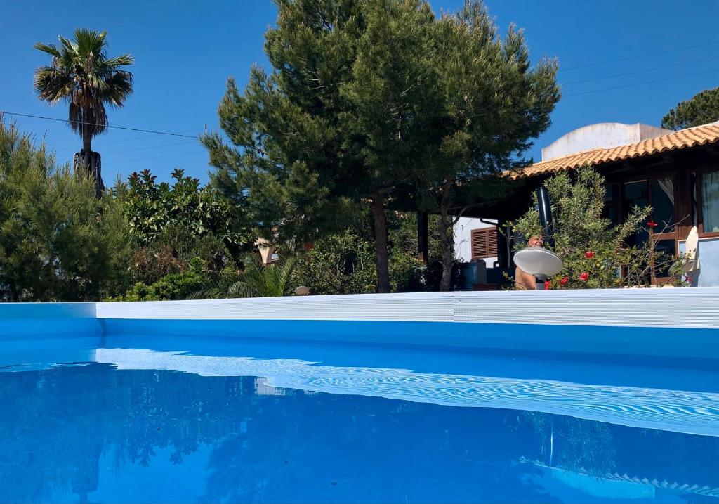 une piscine bleue avec des arbres et une maison dans l'établissement La Casa del Vento Plemmirio, à Plemmirio