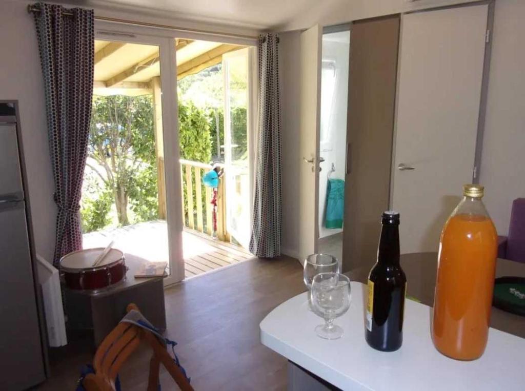 une cuisine avec une bouteille et des verres sur un comptoir dans l'établissement Camping 3 étoiles - Piscine - cbgcaia, à Buis-les-Baronnies