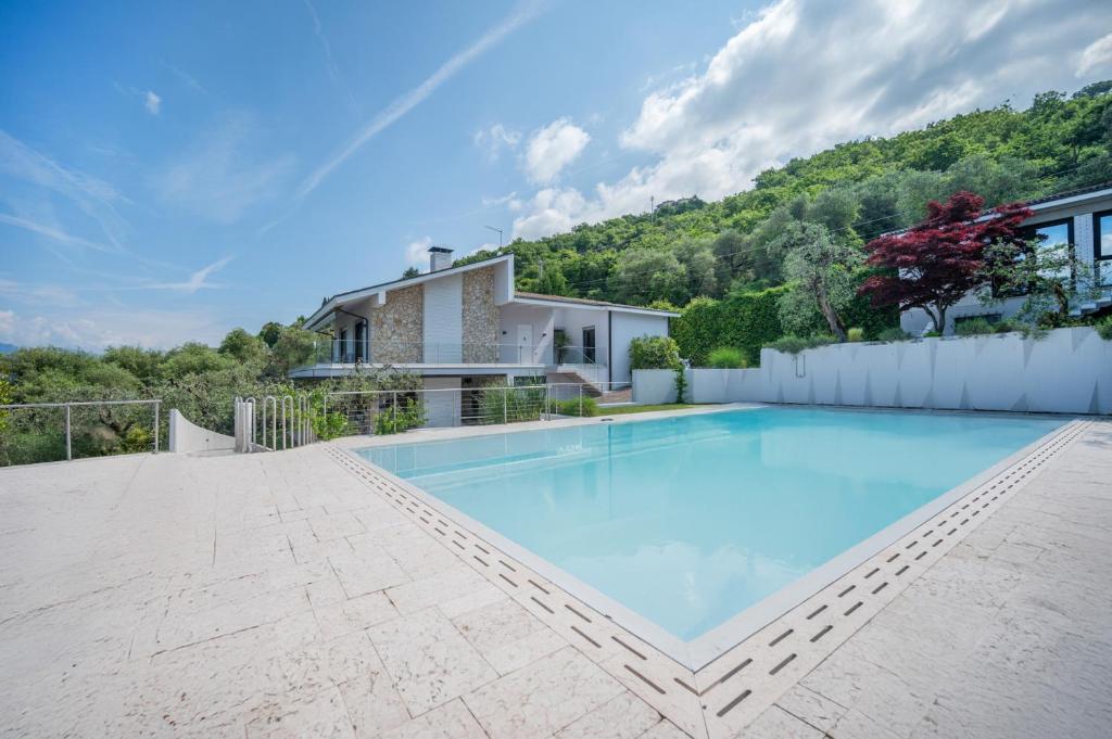 une grande piscine devant une maison dans l'établissement VillasGarda - Villa Lorena Carbona, à Torri del Benaco