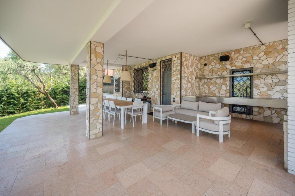 d'une terrasse avec un canapé, des chaises et une table. dans l'établissement VillasGarda - Villa Lorena Carbona, à Torri del Benaco 25 autres photos