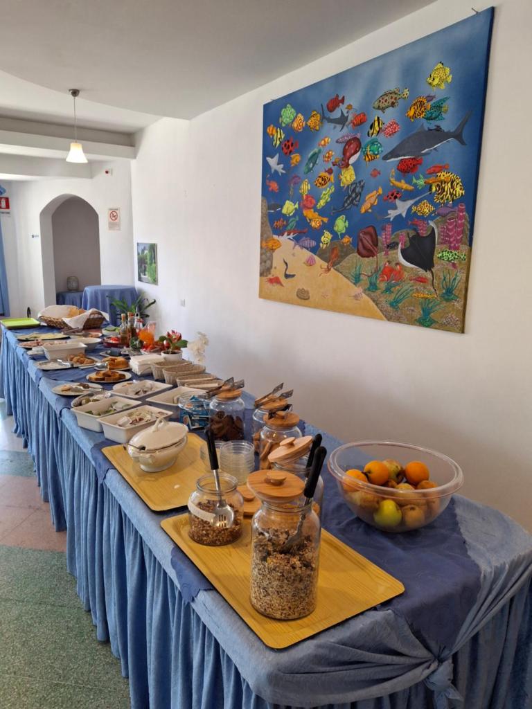 une longue table remplie de assiettes et de bols de nourriture dans l'établissement Centro Ferie Salvatore, à San Felice Circeo