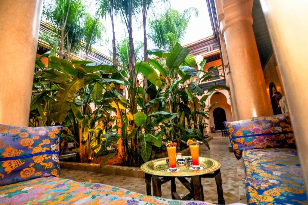 deux boissons sur une table dans une pièce avec des plantes dans l'établissement Al Fassia Aguedal, à Marrakech